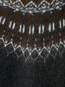 Gros plan du pull en maille Fair Isle montrant le mohair doux et les motifs géométriques