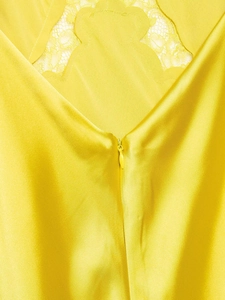 Detail eines gelben Satinkleids mit Spitzenbesatz und unsichtbarem Reißverschluss hinten
