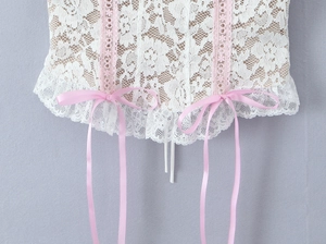 Detail of white lace camisole with pink bow and floral scalloped hem for women
