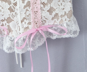 Detail of floral white lace camisole with pink crochet trim and satin bow decoration