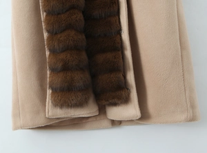 Detailed view of camel wool coat featuring a textured brown faux fur collar and trim