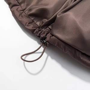 Detail of drawstring hem with adjustable toggle on brown satin hooded winter jacket
