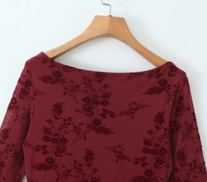Close-up of wine red sheer mesh dress with elegant velvet floral flocking patterns