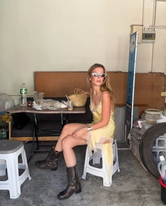 Détail de la robe en satin jaune avec bordure en dentelle blanche dans un atelier