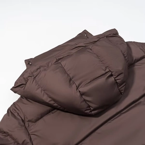 Close-up of dark brown hooded puffer jacket featuring metallic snap buttons and quilting