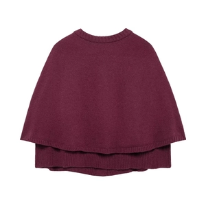 Detail of burgundy knit capelet featuring a round neck and double-layered tiered hemline
