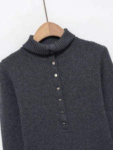 Détail du pull en maille gris foncé avec texture côtelée et boutons argentés décoratifs