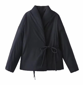 Détail d'une veste croisée noire avec col en V et fermeture par lien à la taille