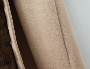 Detailed macro view of camel wool fabric and dark brown faux fur lining on winter coat