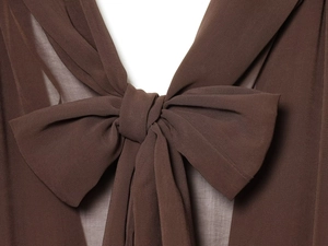 Close-up of deep brown dress neckline featuring a large decorative bow and textured fabric