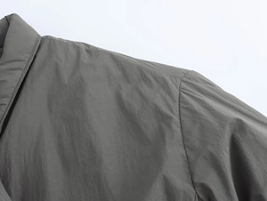 Gros plan sur la couture d'épaule et le tissu gris coupe-vent de la veste kimono