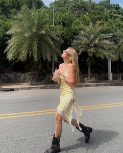 Détail de la robe en satin jaune avec dentelle blanche et fente latérale haute