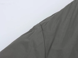 Gros plan sur la texture du tissu synthétique imperméable et les coutures de ce manteau