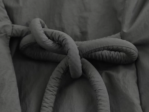 Vue macro détaillée du tissu rembourré gris foncé et du design de la ceinture décorative