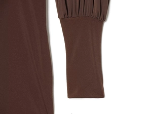 Detailed close-up of dark brown dress sleeve with pleated cuffs and high-density fabric