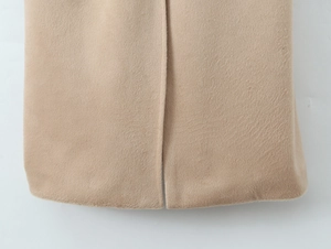 Close-up of side slit hem and fine texture on camel wool blend coat for women