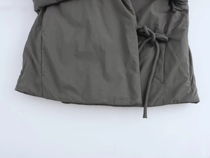 Détail du cordon de serrage latéral et du tissu matelassé gris anthracite de la veste