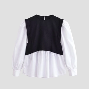 Detail view of contrast black knit and white shirt fabric panels with pleated hem