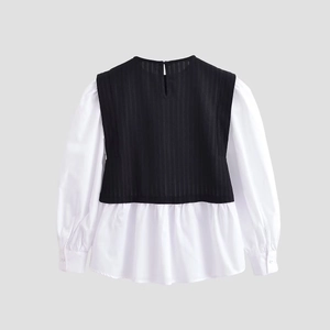 Detail view of contrast patchwork top featuring ribbed black vest and white lantern sleeves