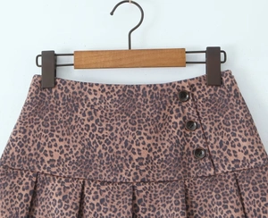 Détails de la jupe plissée léopard à taille haute avec boutons décoratifs sur le côté
