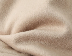 Close-up detail of soft cream faux fur collar with premium plush texture on coat