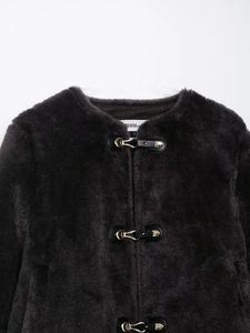 Détail de la veste en fausse fourrure gris foncé avec col rond et boucle en métal