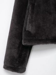 Détail de la texture en fausse fourrure et de la poche sur cette veste d'hiver noire