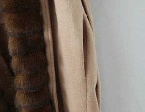 Close-up of beige wool coat featuring luxurious dark brown faux fur collar detail