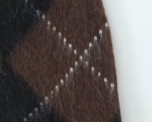 Macro view of textured brown and black argyle knit fabric with fuzzy wool-like fibers