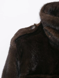 Detail of shoulder epaulettes and resin buttons on a dark brown faux fur jacket