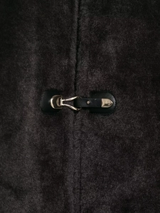 Détail d'une veste en fourrure avec boucle à nœud argenté et texture de poil dense