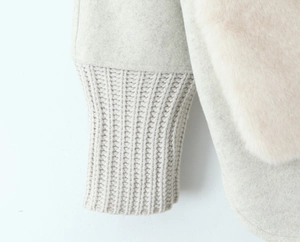 Detail of wool coat sleeve with ribbed knit cuffs and pink faux fur stitching