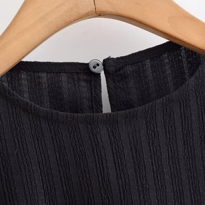 Fashionable black pleated two-piece style top with elegant round neck and button detail