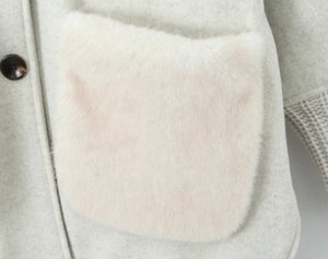 Detail of wool coat featuring a faux fur pocket and ribbed knit cuffs in light gray