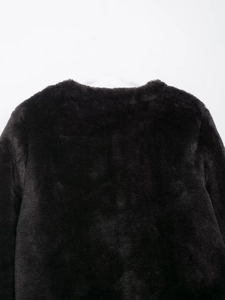 Détail de la texture en fausse fourrure au col d'une veste d'hiver noire