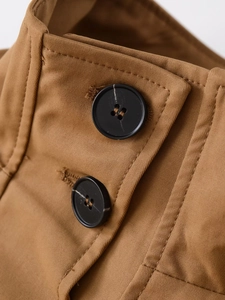 Détail macro du tissu sergé marron avec deux boutons noirs et finitions soignées