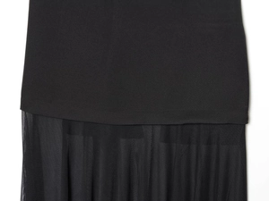 Détail de l'ourlet de robe noire avec épissure de mesh et texture plissée fine