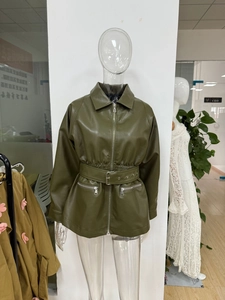 Detail of army green faux leather jacket with metal zippers and waist belt buckle
