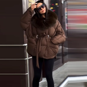 Close-up of thick winter coat featuring a detachable plush faux fur collar and waist drawstring
