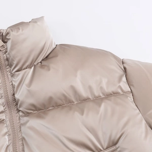 Detail of champagne gold puffer jacket with metallic luster, stand collar and quilting