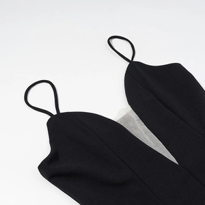 Detail of sexy deep V-neckline with white mesh stitching on black polka dot sling dress