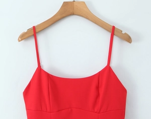 Detail of red spaghetti strap dress showing U-neckline and structural stitching seams