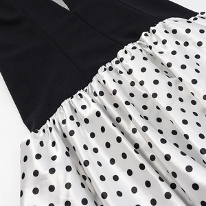 Detail of high waist dress with black top, polka dot satin skirt and gathered stitching