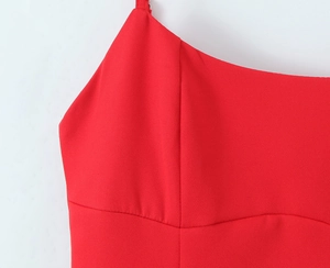 Detail view of red pleated camisole dress with fine straps and structured stitching