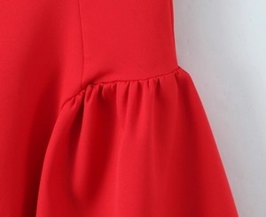 Detailed view of the red sleeveless dress showing ruffle pleats and woven fabric texture