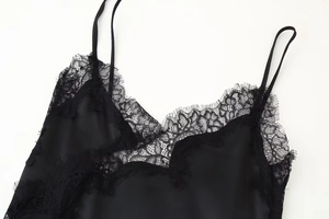 Détail de caraco en satin noir élégant avec bordure en dentelle cil et fines bretelles