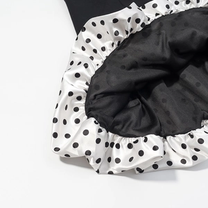 Detailed close-up of ruffle hem with mixed polka dot patterns and satin finish texture