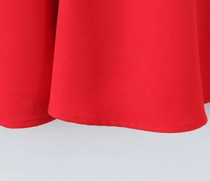 Detailed close-up of the red woven fabric hem with professional flatlock stitching