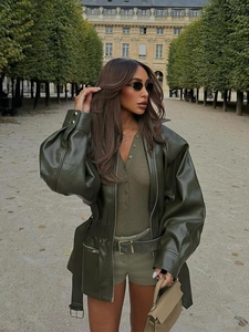 Detail of dark olive leather jacket featuring lantern sleeves and matching waist belt
