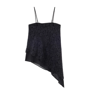 Détail du haut en dentelle noire avec ourlet asymétrique et motif floral délicat